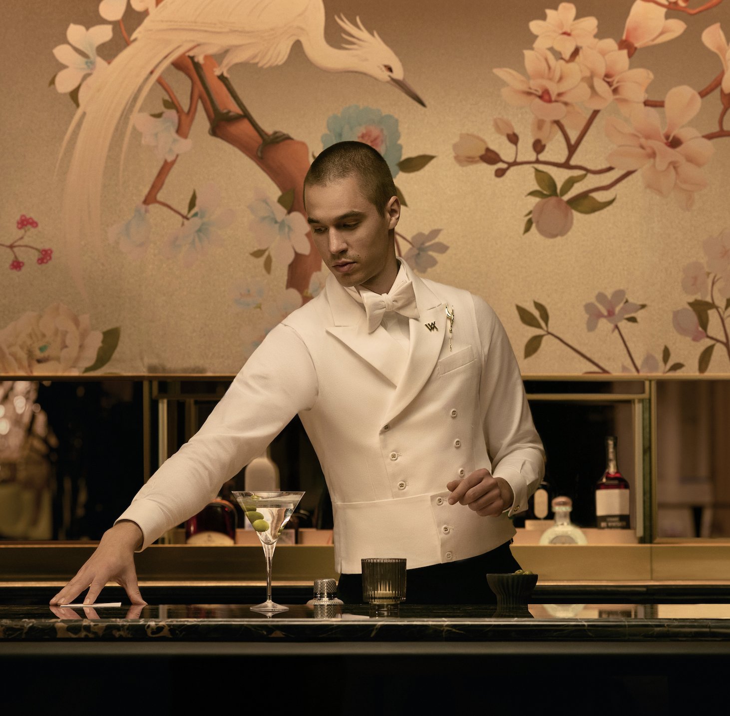 a bartender serving a martini at a dim lit bar